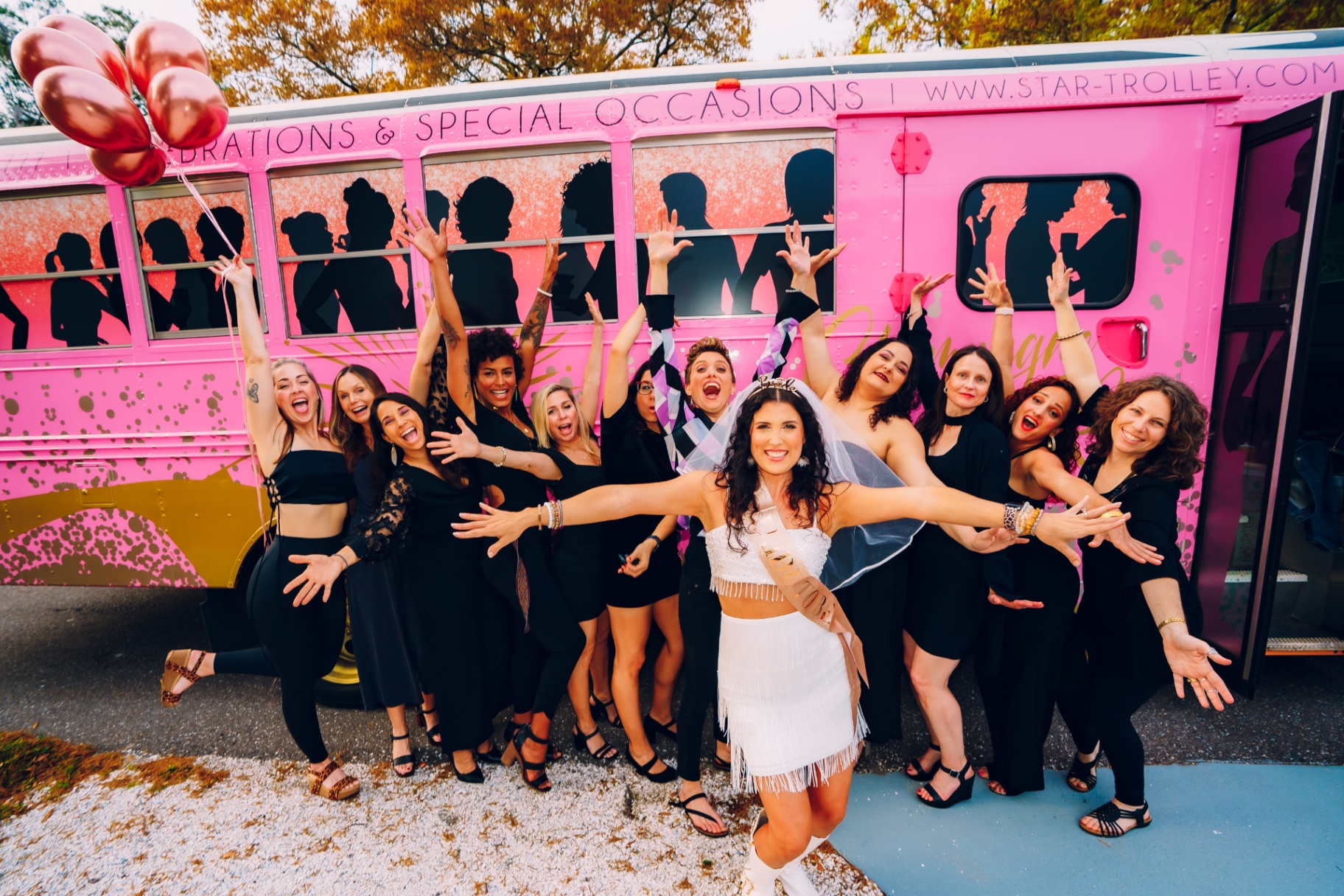 A bachelorette group celebrating in front of the Pink Bus
